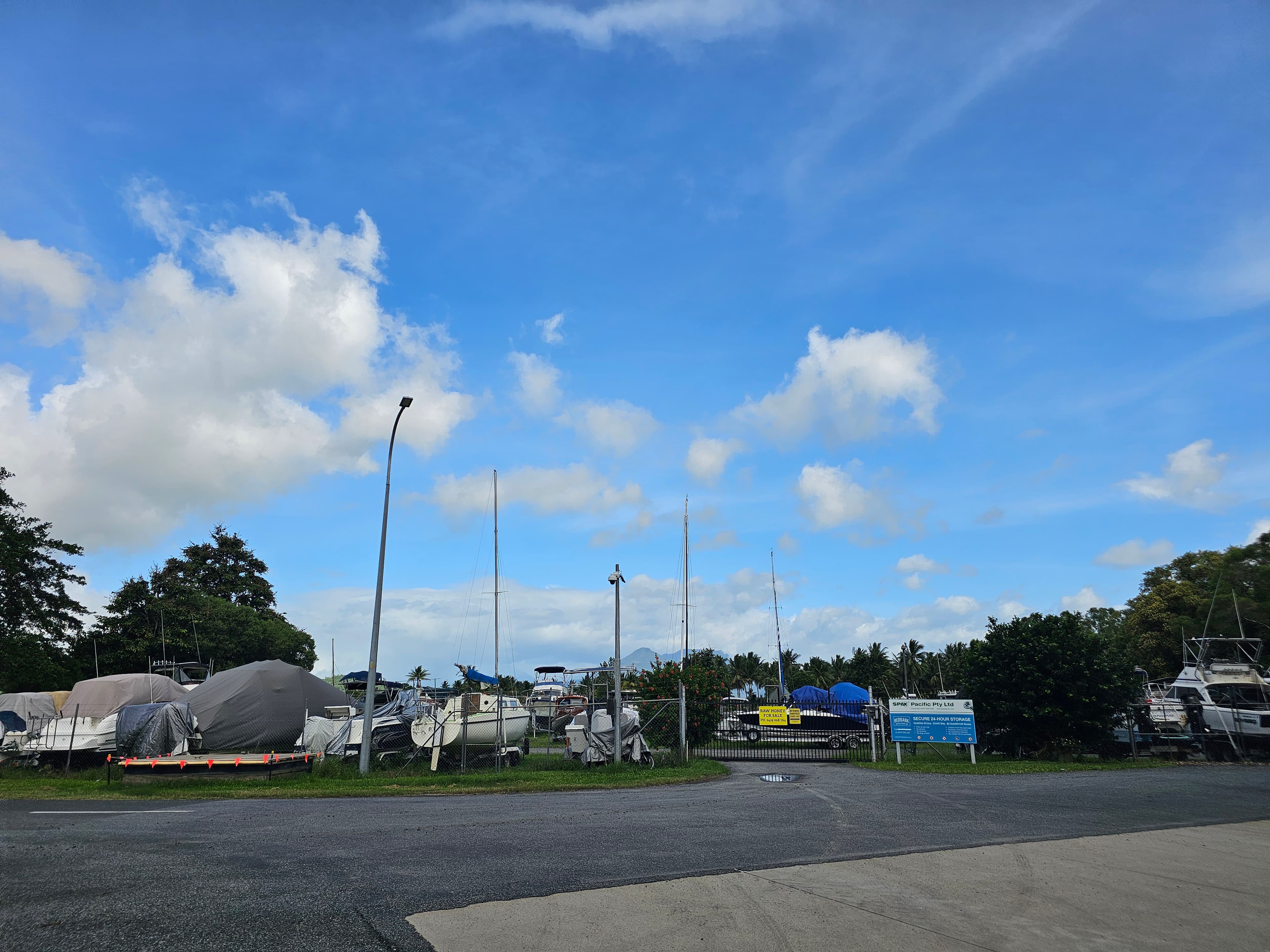 Covered boats on trailers across the sealed hardstand at Cairns Boat Storage
